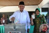 Calon Gubernur Kaltim nomor urut 1 Awang Faroek Ishak didampingi istrinya, Hj Amelia Awang Faroek, memasukkan surat suara saat menyalurkan hak pilihnya di TPS 03 Kelurahan, Pelabuhan Samarinda, Selasa (10/9). Sebanyak 2.794.821 pemilih di 8.082 tempat pemungutan suara (TPS) di Provinsi Kalimantan Timur dan Kalimantan Utara menyalurkan hak pilihnya untuk memilih tiga pasangan calon Gubernur dan Wakil Gubernur Kaltim 2013-2018  (Amirullah/ANTARA)