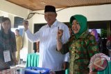 Calon Gubernur Kaltim nomor urut 1 Awang Faroek Ishak didampingi istrinya, Hj Amelia Awang Faroek, menunjukkan jari yang penuh tinta usai menyalurkan hak pilihnya di TPS 03 Kelurahan, Pelabuhan Samarinda, Selasa (10/9). Sebanyak 2.794.821 pemilih di 8.082 tempat pemungutan suara (TPS) di Provinsi Kalimantan Timur dan Kalimantan Utara menyalurkan hak pilihnya untuk memilih tiga pasangan calon Gubernur dan Wakil Gubernur Kaltim 2013-2018 (Amirullah/ANTARA)