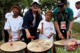 Aktris senior Christine Hakim (kedua kiri) bersama Bupati Samosir Mangindar Simbolon (kanan) memukul tembur pada atraksi budaya "Tambua Tasa" asal Padang Pariaman, dalam rangkaian Festival Danau Toba (FDT) 2013, di Bukit Beta, Samosir, Sumut, Selasa (10/9). Christine Hakim mengunjungi danau terbesar di Indonesia dan Asia Tenggara tersebut, dalam rangka membuat film dokumenter Festival Danau Toba. ANTARA FOTO/Irsan Mulyadi/ed/pd/13