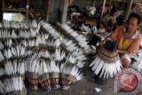 Perajin membuat topi Indian (War Bonnet) di Desa Jiwut, Nglegok, Blitar, Jawa Timur, Sabtu (21/9). Aksesories "indian" merupakan suvenir Piala Dunia 2014 dan sebanyak seribu buah topi per bulannya dikirim ke negeri samba tersebut. ANTARA FOTO/Rudi Mulya/Koz