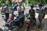 Madiun (Antara Jatim) - Pelajar terjaring razia saat petugas dari Polresta Madiun menggelar razia di beberapa lokasi terhadap pelajar yang mengendarai sepeda motor tanpa Surat Ijin Mengemudi (SIM) di Kota Madiun, Senin (9/9). Polresta Madiun menggelar razia tersebut menyusul adanya kecelakaan di Jakarta yang menelan 6 korban jiwa diakibatkan pengendara belum cukup umur. Dalam razia tersebut, lebih dari 100 orang pelajar sebagian besar pelajar SMP terjaring razia tersebut. FOTO Siswowidodo/13/Chan.

