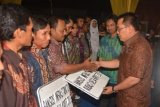 Bondowoso (Antara Jatim) - Menteri Pembangunan Daerah Tertinggal Helmy Faishal Zaini (kanan) didampingi Bupati Bondowoso Amin Said Husni (dua kanan) memberikan bantuan ke sejumlah kelompak tani di Desa Karang Melok, Kecamatan Tamanan, Bondowoso, Jawa Timur, Jumat (11/10). Menteri PDT memberi bantuan kepada sejumlah kelompok tani di Kabupaten Bondowoso yang masih masuk kategori kabupaten tertinggal di Indonesia sebagai upaya pengentasan kemiskinan agar kabupaten itu bisa terlepas dari status kabupaten tertinggal.ANTARA FOTO/Seno/13/DK