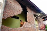 Warga memeriksa dinding rumahnya yang roboh akibat gempa di Desa Neubok Badeuk, Kecamatan Tangse, Kabupaten Pidie, Aceh, Rabu (23/10). Gempa berkekuatan 5,6 SR yang mengguncang 11 desa di kecamatan Tangse itu mengakibatkan rumah rusak berat dan ringan sebanyak 368 unit, sembilan masjid, delapan meunasah, 13 unit sekolah, dua jembatan, 43 unit kios dan ruko serta satu warga meninggal. ANTARA FOTO/Ampelsa/nym/2013.