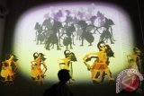 Seorang pengunjung mengamati video mapping wayang kulit Pandawa Melawan Kurawa pada Pembukaan Galeri Indonesia Kaya di West Mall Grand Indonesia, Jakarta, Kamis (10/10). Galeri Indonesia Kaya merupakan ruang publik yang pertama dan satu-satunya di Indonesia yang menyediakan galeri seni budaya Indonesia dengan konsep digital multimedia, permainan tradisional, auditorium pertunjukan yang didedikasikan bagi masyarakat dan terbuka untuk umum tanpa dipungut biaya. ANTARA FOTO/Teresia May