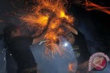 Dua pemuda saling memukulkan api dari sabut kelapa dalam tradisi Mesiat Geni atau perang api di Desa Tuban, Badung, Bali, Sabtu (19/10). Tradisi tahunan tersebut merupakan rangkaian persembahyangan Purnama Kapat (bulan purnama di bulan ke-4 perhitungan Bali) untuk keharmonisan sekaligus memupuk persaudaraan. ANTARAFOTO/Nyoman Budhiana/nym/2013.