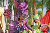 Seorang peserta dengan kostum tema Anggrek pada parade talent Tenggarong Kutai Carnival (TKC) 2013 di Tenggarong, Sabtu (26/10). Bupati Kukar Rita Widyasari membuka fashion on the Street TKC tersebut. (Hayru Abdi/ANTARA Kaltim)