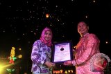 Senior Manager Muri, Paulus Pangka, menyerahkan
piagam Rekor Muri kepada Bupati Kukar Rita Widyasari atas keberhasilan Kukar memecahkan rekor Muri menerbangkan lampion terbanyak sebanyak 5.500 lampion, Sabtu (26/10) malam. (Hayru Abdi/ANTARA Kaltim)