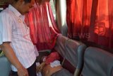 Madiun (Antara Jatim) - Petugas berada di dekat jasad Sukardi (58) yang tergeletak di tempat duduk bus, di Balerejo, Kab. Madiun, Rabu (2/10). Sukardi, warga Surabaya meninggal mendadak di dalam Bus Mira jurusan Jogjakarta - Surabaya saat melintas di Balerejo, Madiun. FOTO Siswowidodo