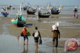 Sejumlah warga berjalan ke arah perahu bermotor, saat akan mudik Idul Adha 1434 H, di Pantai Pagagan, Pademawu, Pamekasan, Jatim, Jumat (11/10). Sejumlah warga Kabupaten Probolinggo, Jatim yang merantau ke Pulau Madura memilih transportasi laut saat akan merayakan Idul Adha bersama keluarga dibanding jalur darat, karena selain ongkosnya jauh lebih murah, jarak tempuh juga lebih singkat. ANTARA FOTO/Saiful Bahri/nym/2013.