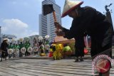 Sejumlah pengunjuk rasa melakukan teatrikal ketika menggelar aksi di Kawasan Bundaran HI Jakarta, Rabu (16/10). Aksi dalam rangka memperingati hari pangan sedunia tersebut mengajak generasi muda untuk kembali menghidupkan sektor pertanian guna mendorong kedaulatan pangan lokal. ANTARA FOTO/Wahyu Putro A
