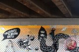 Seniman menggambar mural bertajuk " Toleransi Di Bawah Batu" karya seniman Eko Nugroho di dinding kolong tol Bintaro Jakarta, Rabu, (30/10). Gambar mural ini merupakan bagian dari Jakarta Biennale ke-15 bertemakan " SIASAT yang merupakan perhelatan seni rupa kontemporer berskala internasional dengan menampilkan 48 seniman dan budayawan dalam dan luar negeri yang diselengarakan pada 9-30 November 2013. ANTARA FOTO/Teresia May