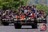 Sejumlah warga bersama prajurit TNI berada di atas tank, saat mengikuti defile pasukan dan kendaraan tempur pada peringatan HUT ke-68 TNI, di Semarang, Jateng, Sabtu (5/10). Peringatan Hari Jadi TNI tahun ini mengangkat tema "Profesional, Militan, Solid dan Rakyat TNI Kuat". ANTARA FOTO/R. Rekotomo