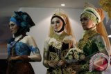 Tiga orang model memperagakan busana pengantin dalam Peragaan Busana pengantin Muslim di Hall MX Mall, Malang, Jawa Timur, Minggu (24/11). Peragaan busana karya para desainer muda tersebut untuk mengenalkan variasi dan kreasi busana pengantin tanpa meninggalkan identitasnya sebagai muslim. ANTARA FOTO/Ari Bowo Sucipto