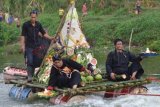 Madiun (Antara Jatim) - Sejumlah warga bersiap melarung sesaji di Kali Madiun, Jumat (8/11). Larung sesaji berupa tumpeng nasi raksasa dan berbagai hasil bumi tersebut merupakan ritual yang mewejudkan rasa syukur kepada tuhan dan merupakan kegiatan budaya yang digelar untuk menyambut Tahun Baru Islam 1435 Hijriyah. FOTO Siswowidodo/13