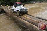 Setelah menunggu selama 18 jam, Tim Ekspedisi Indonesia 4X4 ke Perbatasan akhirnya berhasil menyeberangi sisi timur Sungai Mentarang di Rivan Melasu, Mentarang Hulu, Malinau, Kalimantan Utara, Rabu (6/11) sore. Satu per satu mobil menyeberang melewati jembatan kayu-kayu bulat yang disusun berjajar, melintasi Sungai Mentarang yang deras dan baru meluap setelah hujan sepanjang sore hingga malam di hulunya. (Novi Abdi/ANTARA)
