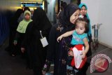 Ratusan Tenaga Kerja Indonesia yang overstay tiba di bandara Soekarno - Hatta, Tangerang, Banten, Sabtu (16/11). Sebanyak 496 TKI overstay kloter ke dua yang bekerja di Arab Saudi dipulangkan ke Indonesia yang terdiri dari 425 wanita dewasa, 26 anak-anak dan 45 bayi. ANTARA FOTO/Rivan Awal Lingga/nym/2013