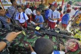 Siswa SD mengamati senjata tempur milik TNI AD yang dipamerkan, di Yonif Arai 752, Manokwari, Papua Barat, Kamis (21/11). Pameran tersebut bertujuan untuk lebih mengenalkan tugas dan tanggung jawab TNI AD, terutama untuk menjaga keamanan NKRI wilayah Timur. ANTARA FOTO/Yudhi Mahatma