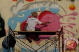 Peserta membuat grafiti di dinding tembok yang kosong sepanjang Jalan Rawa Selatan VI pada ajang Johar Baru Street Art di Johar Baru, Jakarta, Sabtu (2/11). Kompetisi grafiti yang diikuti 29 kelompok remaja tersebut dilaksanakan di tiga tempat yang rawan tawuran dengan harapan melalui kegiatan tersebut dapat meminimalisir tawuran antar kelompok remaja serta ajang untuk menyalurkan bakat bagi remaja yang senang menggambar. ANTARA FOTO/Zabur Karuru