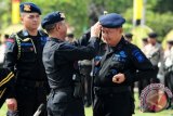 Kapolda Kalbar, Brigjen (Pol) Arie Sulistyo (tengah) memasangkan baret Brimob kepada Kepala Sekolah Pembentukan Calon Perwira (Kasetukpa) Lemdikpol, Brigjen (Pol) Tugas Dwi Apriyanto (kanan) saat upacara peringatan HUT ke-68 Brimob di Mapolda Kalbar, Kamis (14/11).  Brigjen (Pol) Tugas Dwi Apriyanto yang sebelumnya menjabat sebagai Kapolda Kalbar tersebut, dinobatkan sebagai warga kehormatan Korps Brimob Polri. ANTARA FOTO/Jessica Helena Wuysang/13