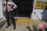 Seorang anggota kepolisian berjaga di depan pintu Kedubes Australia saat Komando Pejuang Merah Putih melempar tomat dan telor ketika aksi di depan Kedubes Australia, Kuningan, Jakarta, Jumat (22/11). Aksi lempar tomat dan telor tersebut merupakan bentuk protes terhadap penyadapan yang dilakukan oleh Australia terhadap sejumlah pejabat Indonesia. ANTARA FOTO/Zabur Karuru/wra/13