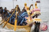 Tim'Dragon Boat' atau perahu naga dari Kabupaten Lingga masuk garis finish urutan pertama dalam penyisihan 'Dragon Boat Race' di perairan Tanjungpinang, Kepri, Sabtu (23/11). Perlombaan Perahu Naga ke-12 di Tanjungpinang diikuti tiga tim dari Malaysia, satu tim dari Singapura dan 28 tim dari sejumlah daerah di Tanah Air dengan memperebutkan total hadiah Rp135 juta. ANTARA FOTO/Henky Mohari
