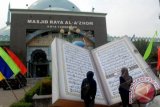 Dua orang melihat replika Al-Quran raksasa yang di pajang di Masjid Raya Al-Azhom, Tangerang, Banten, Senin (4/11). Selain untuk menyambut tahun baru Islam 1435 H, Al-Quran raksasa tersebut juga menyemarakan fetival Al-Azhom 2013. ANTARA FOTO/Lucky.R