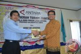 Superintendent Public Communications KPC Yordhen Ampung memberikan buku kepada Direktur SDM dan Umum Perum LKBN ANTARA Naufal Mahfudz pada serah terima jabatan Kepala Biro LKBN ANTARA Kaltim dari Arief Mujayatno kepada Masnun Masud yang berlangsung di gedung PWI Kaltim Jalan Biola Samarinda, Selasa (19/11).  (Amirullah/ANTARA) 
