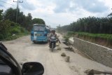 Simalungun, 10/12 - MELINTAS. Sejumlah kendaraan, Selasa, melintas di jalan umum penghubung Kota Pematangsiantar-Perdagangan yang sempat putus akibat longsor pada dua pekan lalu. Dishub Simalungun dan masyarakat Nagori Pematang Sahkuda memberlakukan sistem tutup-buka untuk keamanan, kelancaran lalu lintas yang dimulai Senin sore kemarin. (Foto Antarasumut/Waristo)