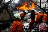 Petugas berusaha memadamkan api yang masih membakar rangkaian KRL setelah terjadi kecelakaan dengan truk tangki BBM di perlintasan KA Pesanggrahan Bintaro, Jakarta Selatan, Senin (9/12). Berdasarkan data sementara tercatat 10 penumpang meninggal dan puluhan lainnya terluka akibat peristiwa tersebut. ANTARA FOTO/ Dhoni Setiawan