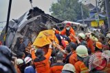 Petugas mengevakuasi korban jiwa peristiwa tabrakan KRL dengan truk pengangkut BBM di perlintasan KA Pesanggrahan Bintaro, Jakarta Selatan, Senin (9/12). Tabrakan tersebut menewaskan 10 orang, dua diantaranya masinis dan teknisi KRL, sementara itu sopir dan kernet dirawat di RSP Pertamina bersama korban luka lainnya. ANTARA FOTO/Yudhi Mahatma
