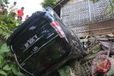 Warga menyaksikan mobil minibus bernomor polisi A 1818 HS yang mengalami kecelakaan di jalur menuju objek wisata Pandeglang - Pantai Carita di Kampung Batubantar, Saketi, Pandeglang, Banten, Senin (2/12). Kecelakaan yang sering terjadi di kelokan tajam dan licin itu akibat minimnya rambu lalu lintas. ANTARA FOTO/Asep Fathulrahman/Koz/Spt//13.