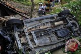 Warga menyaksikan mobil minibus bernomor polisi A 1818 HS yang mengalami kecelakaan di jalur menuju objek wisata Pandeglang - Pantai Carita di Kampung Batubantar, Saketi, Pandeglang, Banten, Senin (2/12). Kecelakaan yang sering terjadi di kelokan tajam dan licin itu akibat minimnya rambu lalu lintas. ANTARA FOTO/Asep Fathulrahman/Koz/Spt//13.
