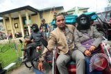 Sejumlah kerabat dari dua tersangka pemakan daging Orangutan, Ignasius Mandur dan Hanafi, menaiki becak usai menghadiri sidang pembacaan vonis sidang praperadilan di Pengadilan Negeri Pontianak, Kalbar, Selasa (3/12). Dalam sidang tersebut, Majelis Hakim PN Pontianak, Erwin Tjong memerintahkan dua tersangka pemakan daging Orangutan yaitu Ignasius Mandur dan Hanafi dibebaskan dari tahanan karena menilai penangkapan dan penahanan mereka yang dilakukan oleh BKSDA Kalbar tersebut tidak sah sebab hanya berdasarkan pemberitaan di Pontianak Post yang terbit pada 5 November lalu, dan bukan tertangkap tangan. ANTARA FOTO/Jessica Helena Wuysang