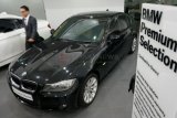 Surabaya (Antara Jatim) - Seorang pria melintas di antara dua mobil BMW di BMW Premium Selection, Surabaya, Selasa (3/12). PT Astra Internasional Tbk - BMW Sales Operation membuka BMW Premium Selection, yang merupakan unit bisnis penjualan kendaraan seken BMW bersertifikat di Surabaya. FOTO Eric Ireng/13