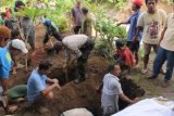 Tulungagung (Antara Jatim) - Sejumlah warga di Desa Sukowiyono, Kecamatan Karangrejo, Tulungagung, Selasa (17/12) terpaksa membongkar pekuburan desanya karena rawan longsor.  Sedikitnya 13 makam dibongkar dan jasadnya dipindahkan ke area aman. Meningkatnya debit air sungai pengendali banjir di desa tersebut menyebabkan sejumlah tangkis dan plengseng sungai hancur dan menggerus area pemukiman penduduk setempat. Foto Destyan Sujarwoko/13/Oka.