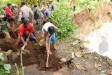 Tulungagung (Antara Jatim) - Sejumlah warga di Desa Sukowiyono, Kecamatan Karangrejo, Tulungagung, Selasa (17/12) terpaksa membongkar pekuburan desanya karena rawan longsor.  Sedikitnya 13 makam dibongkar dan jasadnya dipindahkan ke area aman. Meningkatnya debit air sungai pengendali banjir di desa tersebut menyebabkan sejumlah tangkis dan plengseng sungai hancur dan menggerus area pemukiman penduduk setempat. Foto Destyan Sujarwoko/13