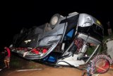 Warga berada di samping bus yang terguling ke kebun di Desa Tuwel, Kabupaten Tegal, Jateng, Selasa (17/12). Bus pariwisata dari Bogor menuju puncak OW Guci itu terguling mengakibatkan enam tewas dan 37 lainnya luka-luka. ANTARA FOTO/Oky Lukmansyah