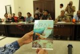 Tulungagung (Antara Jatim) - Wakil Direktur RSUD dr Iskak, dr Mastur, melihat dari dekat lembar foto bukti penelantaran pasien yang disodorkan perwakilan aktivis Aliansi Masyarakat Peduli Tulungagung (AMPTA) di gedung DPRD Tulungagung, Selasa (17/12). Karmini (80), wanita tunawisma yang disebut dalam foto tersebut, dilaporkan meninggal dunia setelah beberapa hari terlantar tanpa mendapat pertolongan di salah satu lorong bangsal rumah sakit daerah tersebut. Peristiwa terjadi pada awal April 2013, namun kasusnya baru diangkat oleh AMPTA setelah seorang warga yang menabrak sekaligus menolong wanita tunawisma tersebut dipenjara dengan tuduhan melanggar UU Lalu lintas saat kecelakaan terjadi. Foto Destyan Sujarwoko/13/Oka.