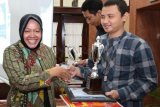 Surabaya (Antara Jatim) - Wali Kota Surabaya Tri Rismaharini (kiri) memberikan penghargaan kepada wartawan Perum LKBN Antara, Abdul Hakim (kanan), yang menyabet juara kedua dalam lomba tulisan 