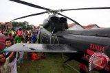 Warga memperhatikan helikopter milik TNI AD yang mendarat darurat di Lapangan Desa Boledan, Klampok, Brebes, Jateng, Senin (9/12). Tiga helikopter TNI AD jenis Bell 412 dan Bolcow 105 tujuan Jakarta-Semarang itu mendarat darurat sekitar pukul 13.00 WIB akibat cuaca buruk disertai hujan deras. ANTARA FOTO/Oky Lukmansyah/wra/13