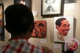 Pengunjung memperhatikan karikatur berjudul Jokowi pada pembukaan pameran Pesta Kartun Akhir Tahun di Galeri Cipta 3, TIM, Jakarta, Rabu (18/12) malam. Pameran dalam rangka HUT ke-24 Persatuan Kartunis Indonesia (PAKARTI) itu berlangsung hingga Minggu (29/12). ANTARA FOTO/Dodo Karundeng/ss/Spt/13