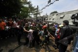 Petugas berusaha mengevakuasi korban kecelakaan kereta rel listrik di Bintaro, Jakarta, Senin (9/12). KRL tujuan Stasiun Tanah Abang tersebut menabrak truk tangki bahan bakar minyak bermuatan 24.000 liter premium di perlintasan kereta api Bintaro. ANTARA FOTO/Puspa Perwitasari/ed/Spt/13