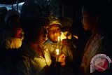 Sejulah anak-anak berpakaian adat Bali membawa lilin sebagai penerangan pada perayaan Hari Natal di Gereja Katolik Hati Kudus Yesus Palasari, Jembrana, Bali, Rabu (25/12). Umat Katolik di desa wisata tersebut telah mewarisi tradisi pentas kesenian, iringan gamelan Bali serta berpakaian adat Bali saat mereka ke Gereja. ANTARA FOTO/Wira Suryantala/wra/13.