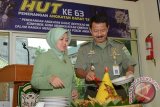 Kapendam Iskandar Muda  Kolonel Arh Subagio Irianto didampingi isteri memotong tumpeng di Makodam setempat di Banda Aceh, Senin (13/1). Pemotong tumpeng itu dalam rangka memperingati HUT ke-63 Penerangan TNI AD.ANTARAACEH.COM /Pendam IM.