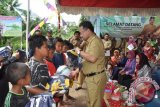 mARTAPURA, 9/1 - Bupati Banjar Sultan Khairul Saleh menyerahkan bola dan kostum olahraga saat turun  ke pelosok desa untuk sosialisasi Jaminan Kesehatan  Nasional(JKN) di desa Lumpangi Kecamatan Pangaron, Rabu (9/1). JKN mulai berlaku  per 1 Januari 2014 yang dilayani Puskesmas dan rumah sakit.