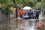 Sejumlah anggota Badan Penanggulangan Bencana Daerah (BPBD) Kota Denpasar membantu evakuasi wisatawan yang terjebak banjir di kawasan wisata Sanur, Denpasar, Kamis (2/1). Hujan yang mengguyur Bali sejak dua hari terakhir telah menyebabkan sejumlah kawasan pemukiman warga dan wisatawan di Denpasar tergenang. ANTARA FOTO/Nyoman Budhiana/nym/2013.