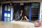 Warga berusaha keluar dari rumahnya yang jebol sambil membawa barang miliknya ketika banjir melanda Kelurahan Petogokan, Kebayoran Baru, Jakarta Selatan, Senin (13/1). Hujan deras yang mengguyur selama sehari itu mengakibatkan sejumlah wilayah di Jakarta terendam banjir. ANTARA FOTO/Muhammad Adimaja/nym/2014.