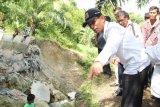 :  Bupati Simalungun JR Saragih meninjau irigasi yang jebol di Desa Rambung Merah,  Kecamatan Siantar, Kamis (16/1). JR. Saragih berjanji akan segera memperbaiki irigasi yang selama ini berfungsi mengairi sawah seluas 1.144 hektare  di empat desa. (Foto Antarasumut/Waristo)