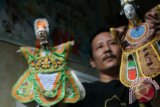 Seorang perajin memperlihatkan hasil karyanya satu set wayang Potehi di Tulungagung, Jawa Timur, Selasa (21/1). Hasil kerajinan tersebut kini makin diminati masyarakat terutama menjelang pergantian tahun pada kalender China atau Imlek dan dijual seharga Rp 50 juta - Rp 75 juta per set. ANTARA FOTO/Sahlan Kurniawan/ss/nz/14.