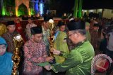 Walikota Pontianak,Sutarmidji menyerahkan piala kepada juara I MTQ ke 25 Kota Pontianak. Musabaqah Tilawatil Quran (MTQ) ke-25 Tingkat Kota Pontianak sukses digelar. Ajang perlombaan bagi qori dan qoriah serta cabang-cabang lainnya ini mengantarkan Kecamatan Pontianak Utara sebagai juara umum menyisihkan lima kecamatan lainnya.(Foto Antara Kalbar / Andilala)